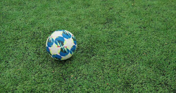 Close-up of Rolling Soccer Ball on Football Field, Rainy Weather