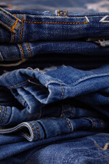Blue jeans denim heap background. Jeans fabric stack as material surface