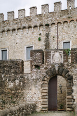 Medieval castle of Orsini Odescalchi in Nerola, Rome close-up. Arched passage, stone bridge, stone facade.