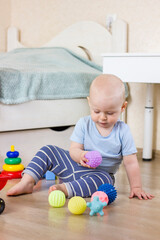 Cute baby boy toddler playing with massage balls.
