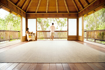 Couple relaxing at home in backyard gazebo structure