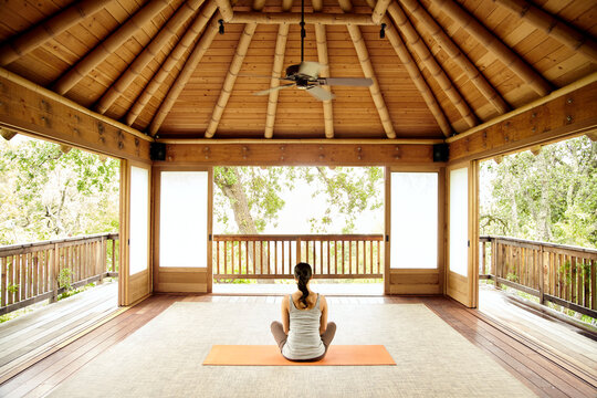 Woman in sitting meditation and doing yoga on deck