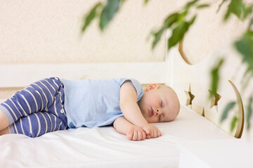 Cute sleeping baby boy in a bed.