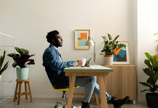 Relaxed black man having coffee at cool office