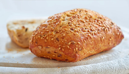 Food stuff. A fresh home baked loaf of wholegrain or wholewheat, sesame seed bread on a board, ready to be cut. For a healthy diet and lifestyle eat food thats high in fibre.