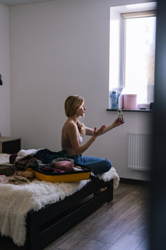 Woman having online communication during preparation to trip 