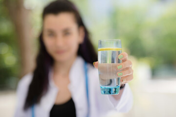 Detox concept. Close up of dietitian doctor holding a glass of water with lemon.