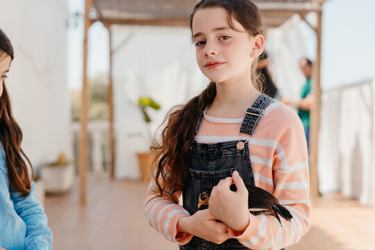 Girl holding baby chick in backyard