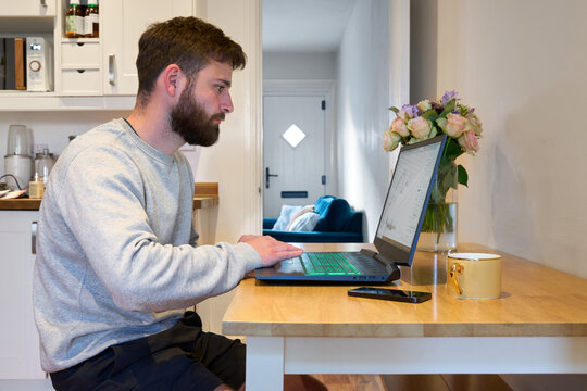 Man working from home sitting a kitchen table