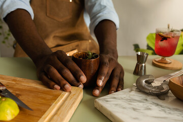 Cropped bartender making drink with rosemary