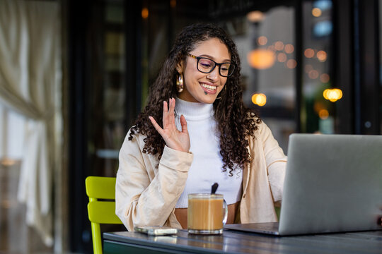 Woman With Glasses Waves To Someone On A Video Chat On Her Computer 