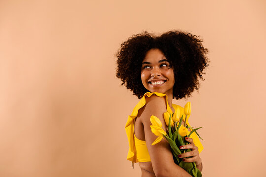 Positive woman with flower bouquet studio portrait