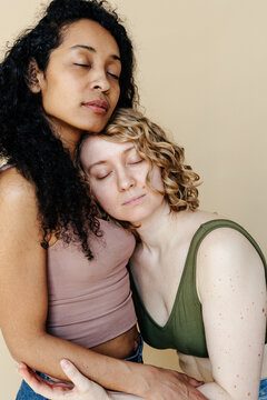 Multiracial women hugging in studio