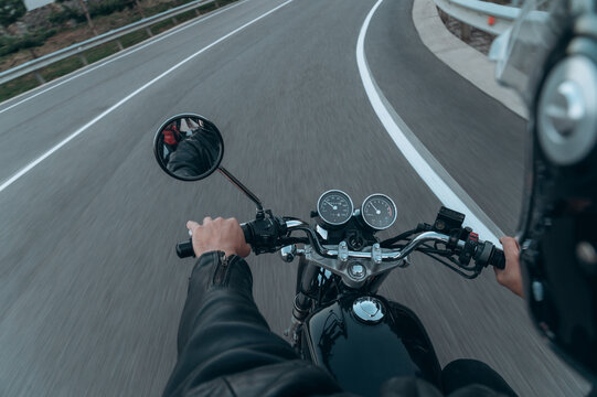 Crop man driving fast motorcycle on road