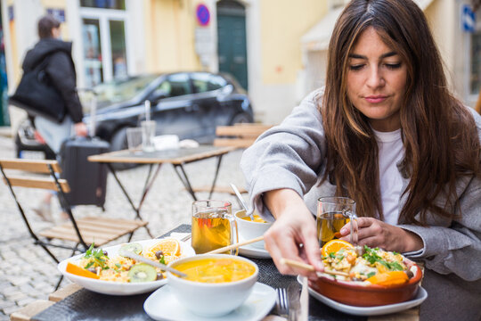 Woman enjoying meal on a terrace outdoors