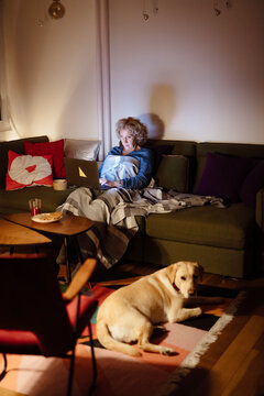 Woman relaxing at home with her dog