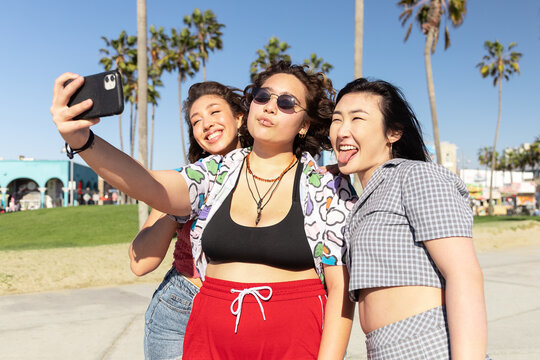 Gen-z Friends Having Fun Roller Skating Together By The Beach