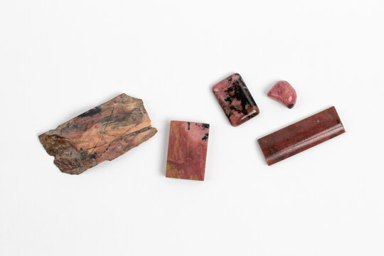 Rough and polished Rhodonite samples. Pink Manganese silicate mineral with an opaque transparency