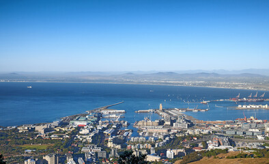 Aerial view of a city and ocean with harbor in Cape Town during the day. Scenic landscape view of a small port, urban buildings and seascape against a blue sky with copy space in South Africa