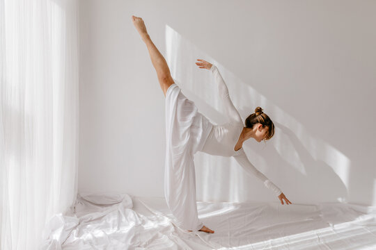 Fototapeta Female ballerina bending forward with raised leg