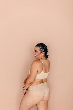 Laughing mixed-race woman in underwear