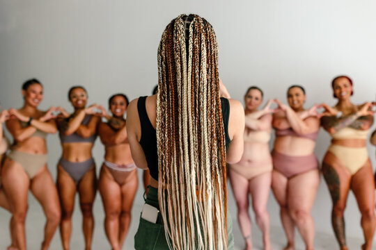 Girl with braids takes photo of diverse women