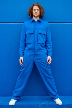 Redhead man in blue clothes with legs apart