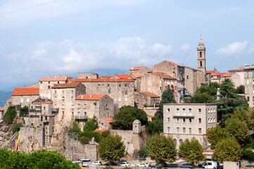 Fototapeta premium Old buildings of the town of Sartene on the island of Corsica in France. Town with houses and church tower in the mountains.