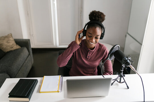 Delighted black lady hosting radio program and smiling
