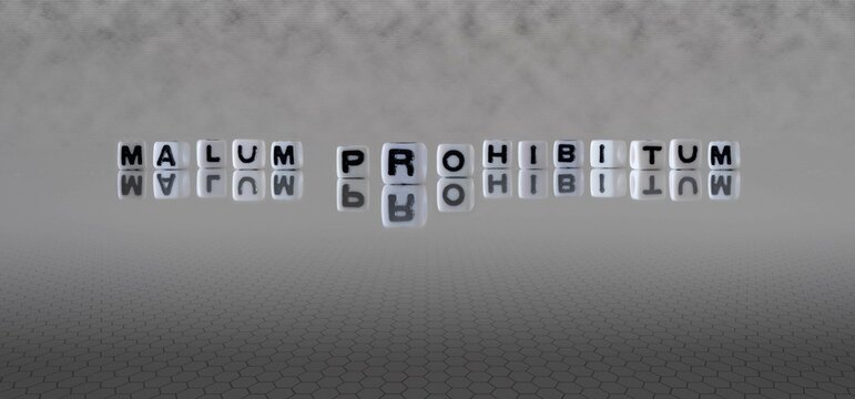 malum prohibitum word or concept represented by black and white letter cubes on a grey horizon background stretching to infinity