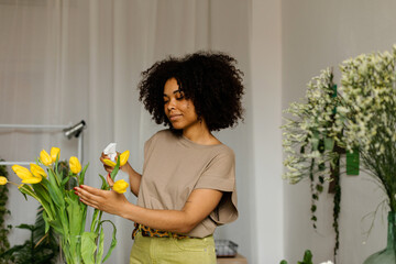 Florist woman watering vase in studio