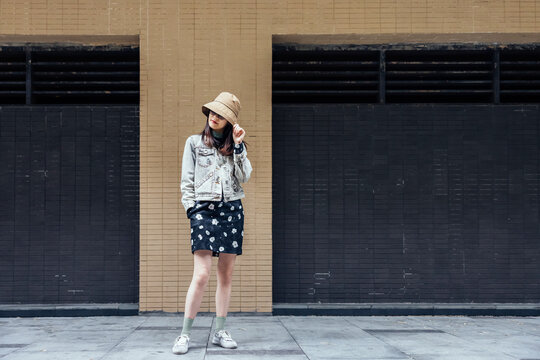 Asian Woman Standing In Front Of The Wall