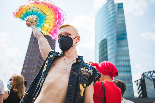 Man with a rainbow hand fan during Pride
