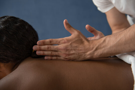 Crop masseur rubbing back of customer