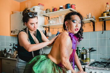 Woman applying glitter on man's back in the kitchen
