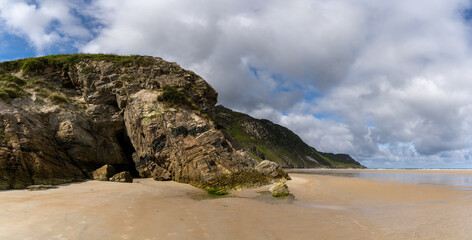 Fototapeta na wymiar panorama landscape view of Maghera Beach with the entrance to one of the caves in the rocks