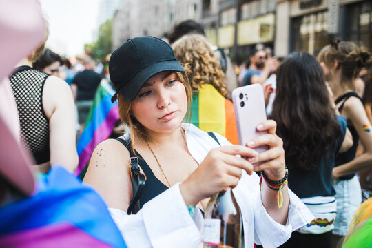 Young woman with rainbow eyelashes taking a selfie during Pride