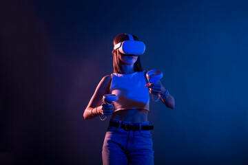 Fototapeta na wymiar Video Gaming Concept. women playing with virtual reality goggles, VR headset, modern technology glasses with neon light on a colored background