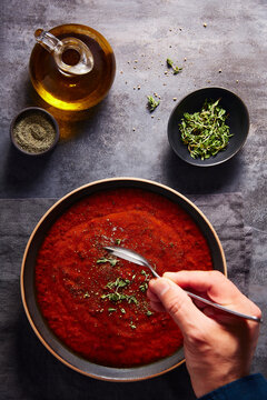 Male Hand Dipping into Tomato Red Pepper Soup