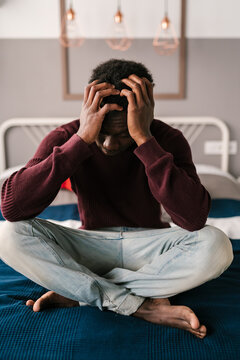 Overwhelmed black man touching head
