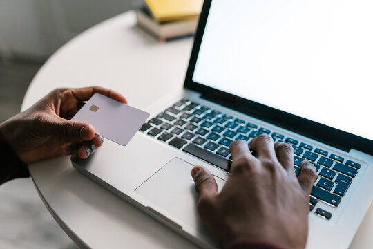 Crop black man paying for order in online shop