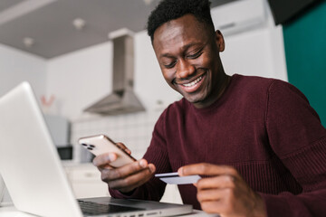 Cheerful black customer reading credit card credentials