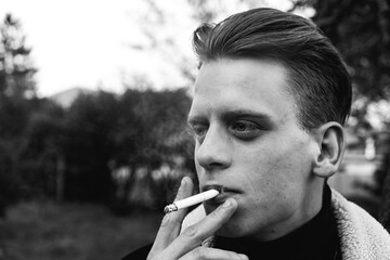 black white photo of a young man smoking a cigarette