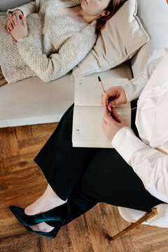 Unrecognizable psychologist making notes during session