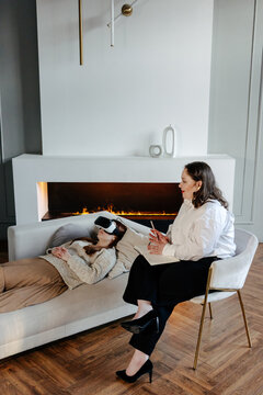Psychologist talking to tranquil female patient during VR therapy