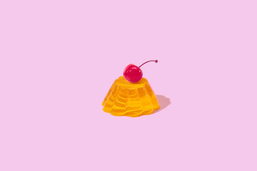 Yellow jelly decorated with red maraschino cherry