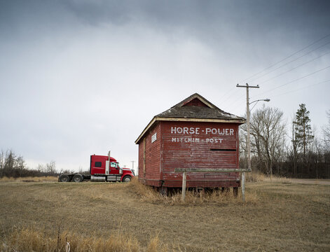 An old horse building with a big rig truck.