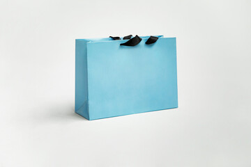 Mock-up of blank craft package, mockup of blue paper shopping bag with black handles over white background