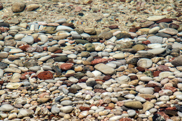 Pebble beach surface closeup through clear calm sea water