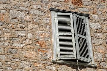 Wooden window shutters on old stone house closeup